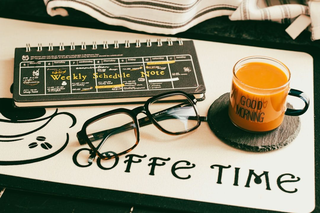 Coffee, glasses and planner on a desk.